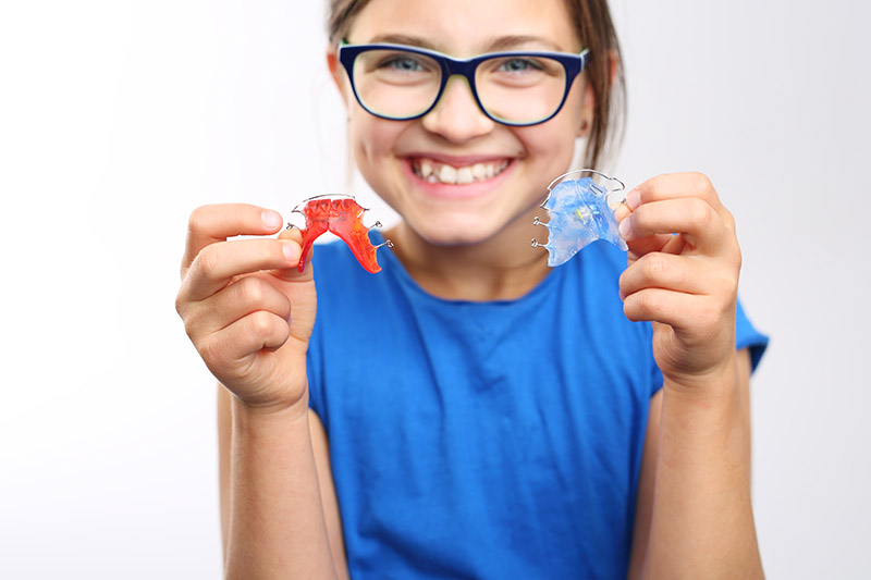 Enfant tenant deux appareils orthodontiques