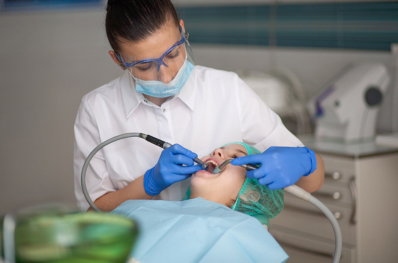 Dentiste en train de prodiguer des soins dentaires à un enfant